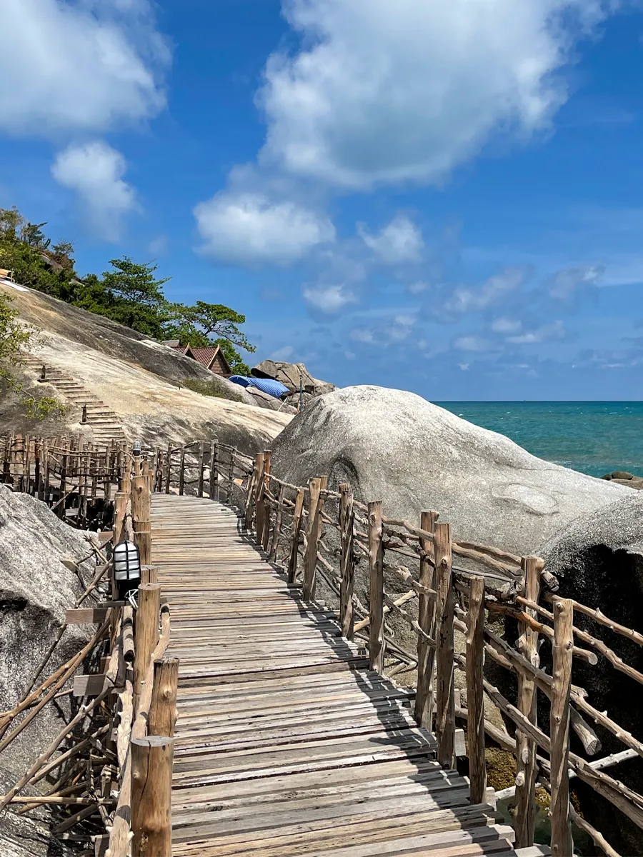 Wooden boardwalk over rocks leading to the sea on Koh Phangan